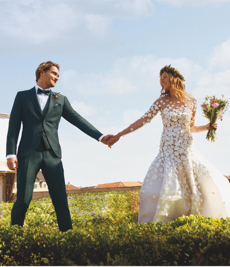 Hochzeitspaar auf Wiese, Vintage-Style, Anzug dreiteilig dunkelgrün mit Fliege