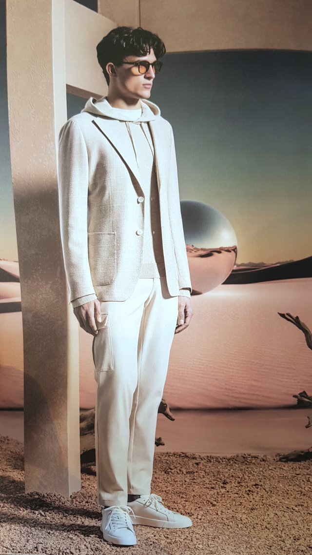 hoodie Smart Casual - Mann in Kombination aus strukturiertem Sakko, Hoodie und legerer Hose in Off-White