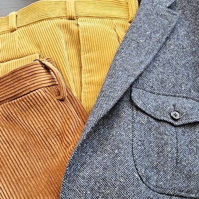 goldgelbe und rostfarbene Hose in gröberem Cordstoff kombiniert mit einem blauen Donegal-Tweed mit gelben Farbsprenkeln